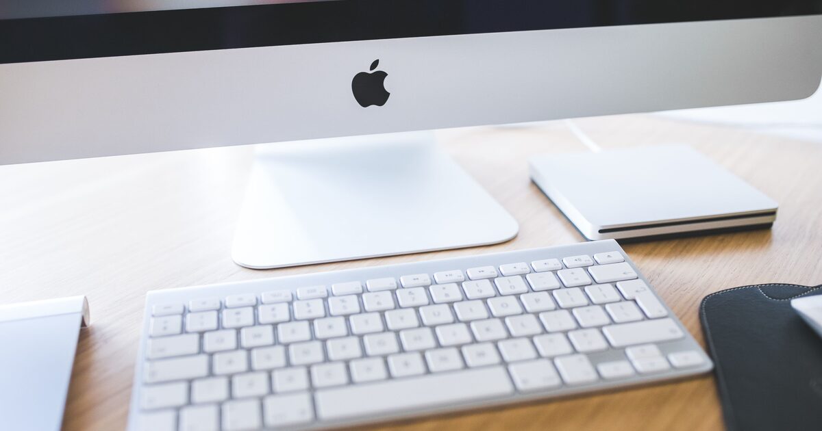 iMac med tangentbord och styrplatta på ett ljust skrivbord